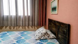 a bedroom with a bed with a pillow and a window at Apto Gonzaga a 20m da praia -Ar Split & Pet Friendly in Santos