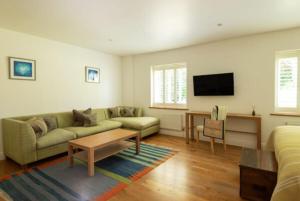 a living room with a couch and a tv at St Enodoc Hotel by Paul Ainsworth in Wadebridge
