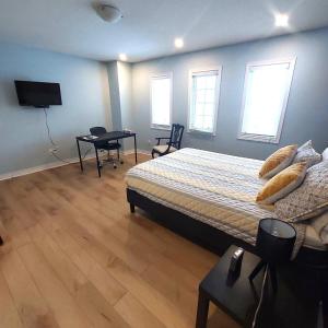 a bedroom with a bed and a table and a television at Nimo Homestay in Guelph