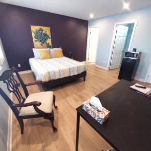 a bedroom with a bed and a chair in a room at Nimo Homestay in Guelph