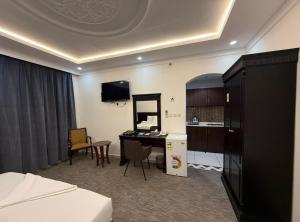 a hotel room with a bed and a desk and a kitchen at فندق اعالي الحجاز - مكة المكرمة in Mecca