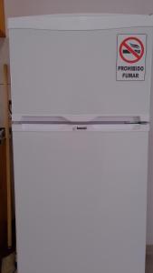 a white refrigerator with a sign on the top of it at "ATARDECER" Departamento a pocos minutos de termas in Chajarí