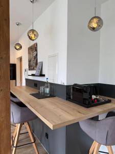 a kitchen with a wooden counter with two bar stools at Pro Home Mara private Sauna in Bad Oeynhausen +28 photos