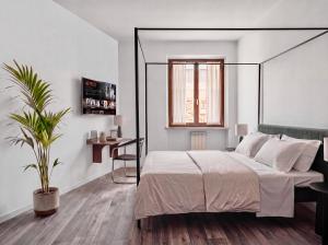 a bedroom with a large bed and a plant at OverGarden Rooms in Dossobuono