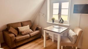 a living room with a couch and a table at Söl'ring Hüs "kleiner traum rantum" in Rantum