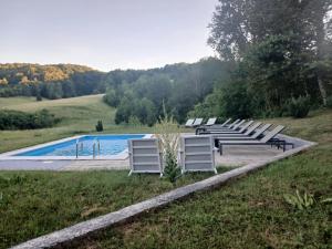 a row of white chairs sitting next to a pool at VILLa LIKA A NNEX in Plitvička Jezera