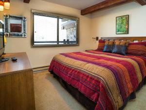 a bedroom with a bed and a desk and a window at Lift One Condominiums - Unit 409 in Aspen