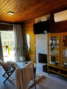 a living room with a fireplace and a television at Chalé Saúde in Venda Nova do Imigrante