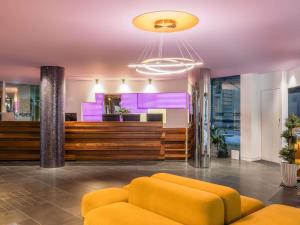 a lobby with a yellow couch and a bar at The Sebel Melbourne Docklands Hotel in Melbourne +86 photos