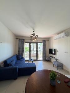 a living room with a blue couch and a table at Chalet in the marassi marina 2 in El Alamein