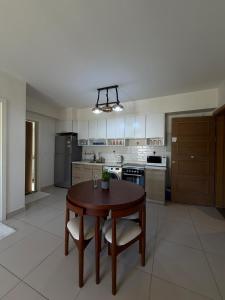 a large kitchen with a wooden table and chairs at Chalet in the marassi marina 2 in El Alamein