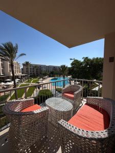 a balcony with chairs and tables with a view of a pool at Chalet in the marassi marina 2 in El Alamein