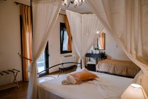 a bedroom with a bed with white curtains at Hotel Agnanti Unique Hospitality in Kastoria +55 photos