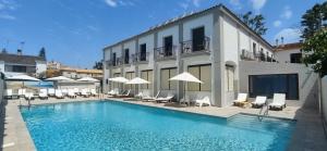 a hotel with a swimming pool with chairs and umbrellas at PARAISO PLAYA Hotel in Isla Cristina