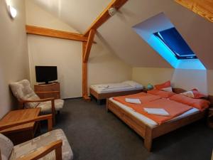 a attic room with two beds and a tv at City Hotel Siófok in Siófok