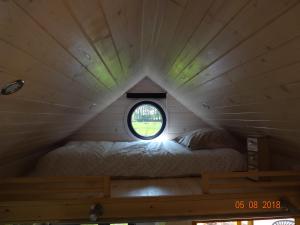 a bed in a tiny house with a window at Tiny House Climatisée Bernières in Bernières