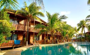 a resort with a large swimming pool with palm trees at Coconut by ÓOL Hotels in Holbox Island