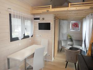 a small living room with a white table and chairs at Tiny House Climatisée Bernières in Bernières