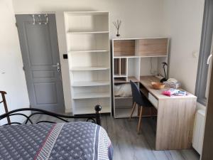 a bedroom with a desk and a bed and a desk and shelves at La Petite Maison dans la Prairie in Cholet