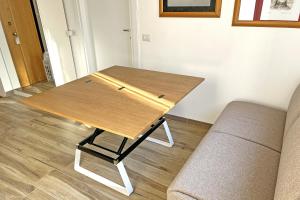 a wooden table in a living room with a couch at Casa DiMì - 2 BR, 2 en-suite bath, 2 min M5, Smart lock in Milan