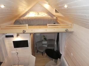 a small bedroom with a bed in a tiny house at Tiny House Climatisée Bernières in Bernières