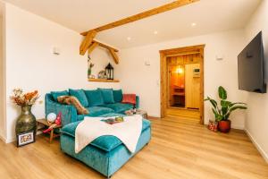 a living room with a blue couch and a tv at Harzlodge Lebenstraum in Braunlage