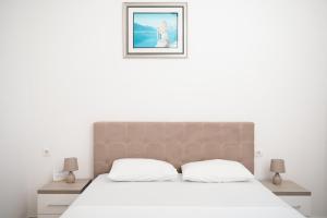 a bedroom with a large bed with white sheets at Villa Antonio in Ulcinj