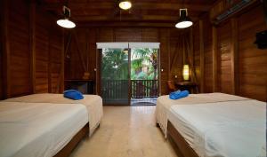 a room with two beds with blue pillows in it at Coconut by ÓOL Hotels in Holbox Island