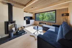a living room with a blue couch and a tv at Forest&Lake Retreat in Dehtáře