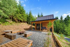 a cabin in the woods with a bench and tables at Forest&Lake Retreat in Dehtáře