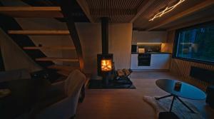 a living room with a fireplace and a table and a kitchen at Forest&Lake Retreat in Dehtáře +23 photos