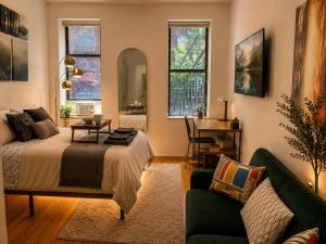 a bedroom with a bed and a couch and windows at Union Nest in New York