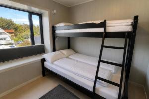a bunk bed in a room with a window at LofotenApartmentOne in Stamsund