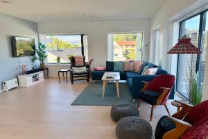 a living room with a blue couch and chairs at LofotenApartmentOne in Stamsund