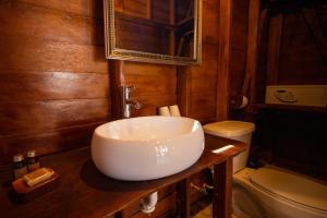 a bathroom with a sink and a toilet and a mirror at Coconut by ÓOL Hotels in Holbox Island +62 photos