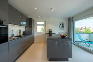 a kitchen with black cabinets and a large window at Domizil Relax - Fewo Seeluft in ruhiger zentraler Lage in Überlingen