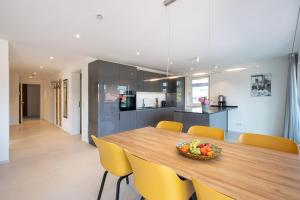 a kitchen and dining room with a wooden table and yellow chairs at Domizil Relax - Fewo Seeluft in ruhiger zentraler Lage in Überlingen