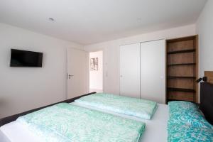 a bedroom with two beds and a flat screen tv at Domizil Relax - Fewo Seeluft in ruhiger zentraler Lage in Überlingen