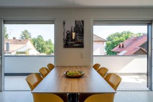 a dining room with a table and chairs and large windows at Domizil Relax - Fewo Seeluft in ruhiger zentraler Lage in Überlingen +17 photos