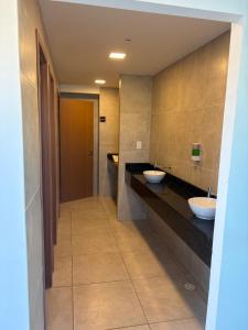a bathroom with two sinks and a hallway at Flat na Praia dos Carneiros - Resort Max Carneiros Suítes in Tamandaré +19 photos