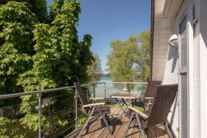 a balcony with two chairs and a table on it at Ferienwohnung Blaupause Reichenau mit Seezugang und Wiese zum Entspannen in Reichenau