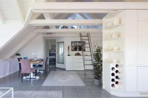 a kitchen and dining room with white cabinets and a table at Ferienwohnung Blaupause Reichenau mit Seezugang und Wiese zum Entspannen in Reichenau