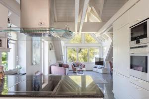 a kitchen and living room with a glass table at Ferienwohnung Blaupause Reichenau mit Seezugang und Wiese zum Entspannen in Reichenau