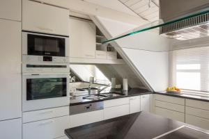 a kitchen with white cabinets and a staircase at Ferienwohnung Blaupause Reichenau mit Seezugang und Wiese zum Entspannen in Reichenau