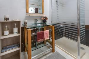 a bathroom with a sink and a glass shower at Demeure Olea, Chambres D'hôtes in Chérac