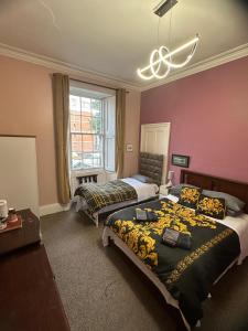 a bedroom with two beds and a chandelier at IVY- Braveheart Guest House in Edinburgh +34 photos