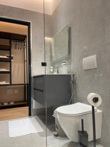 a bathroom with a toilet and a glass shower at Olivium Rooms in Vlorë +93 photos