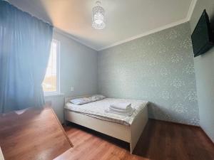 a small bedroom with a bed and a window at Guest house BIKA in Chon-Sary-Oy