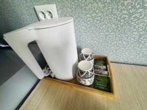 a white blender sitting on a wooden tray on a counter at Guest house BIKA in Chon-Sary-Oy