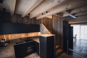 a kitchen with wooden walls and a stove top oven at Kessler's Mountain Lodge in Natz-Schabs